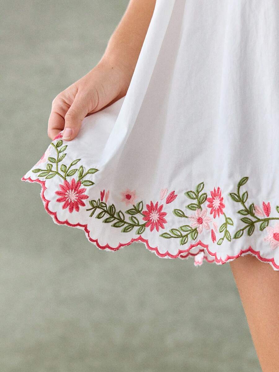 White gathered-waist dress with scalloped pink edging