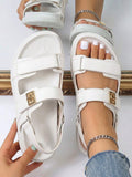 Overhead view of white adjustable platform sandals with gold buckle and metal rings