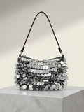 Detail view of dangling round paillettes on black shoulder bag