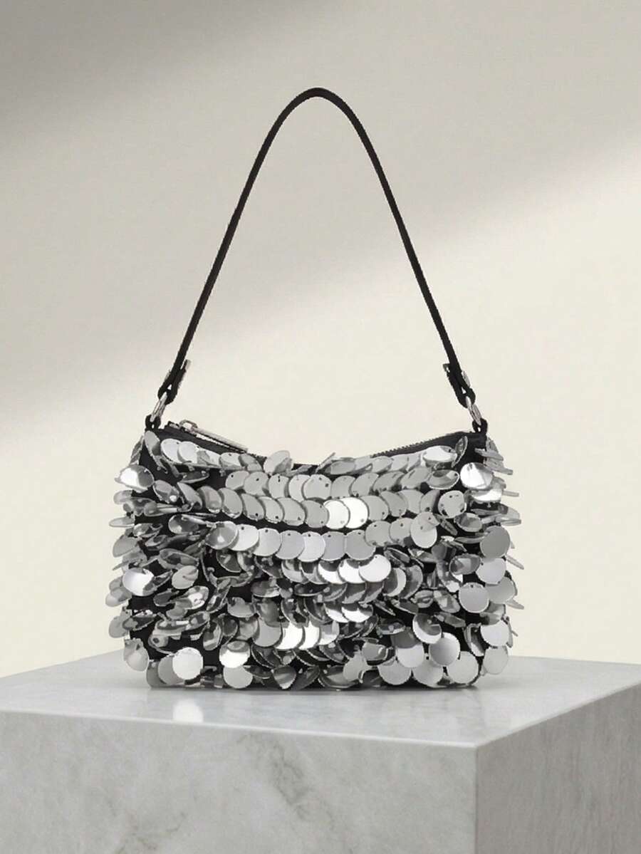 Detail view of dangling round paillettes on black shoulder bag
