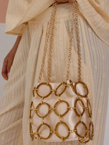 Cream drawstring bucket shoulder bag with tortoiseshell ring cage and gold chain strap