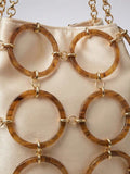 Close view of chain shoulder bucket bag with round tortoise rings and drawstring top