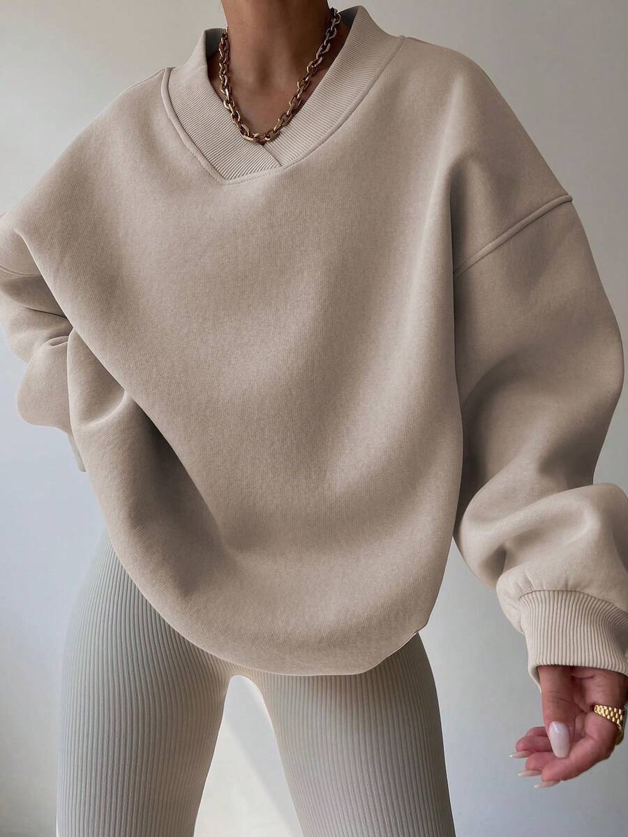 Front view of apricot oversized V-neck sweatshirt with balloon sleeves