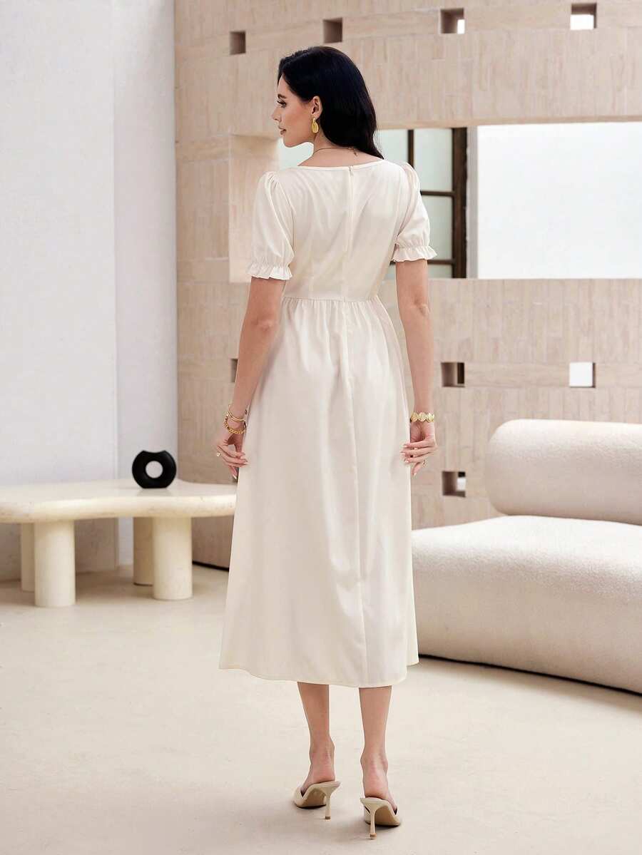 Front seated view of ivory floral midi dress with square neck puff sleeves and printed skirt