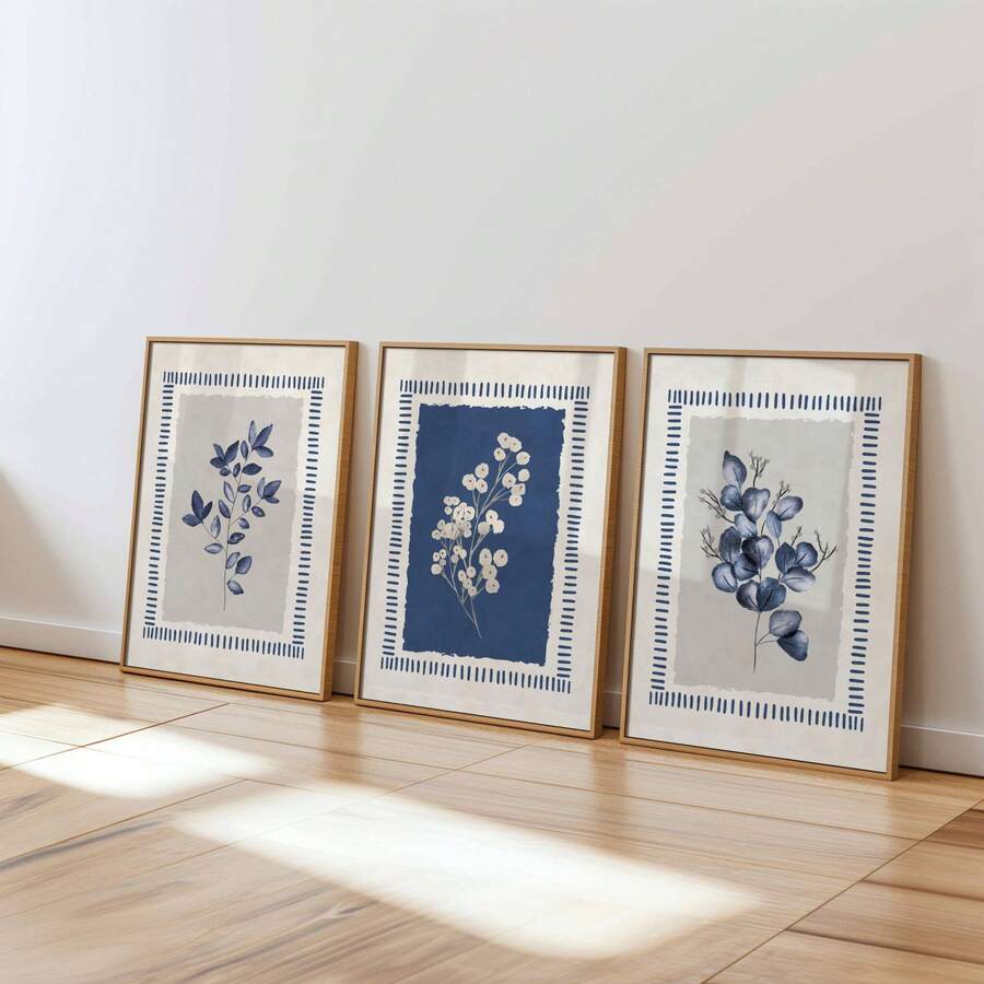 Front bedroom wall mockup of three indigo botanical prints in white frames above a neutral bed