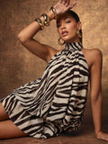 Seated view of cream and black striped halter mini dress with draped skirt