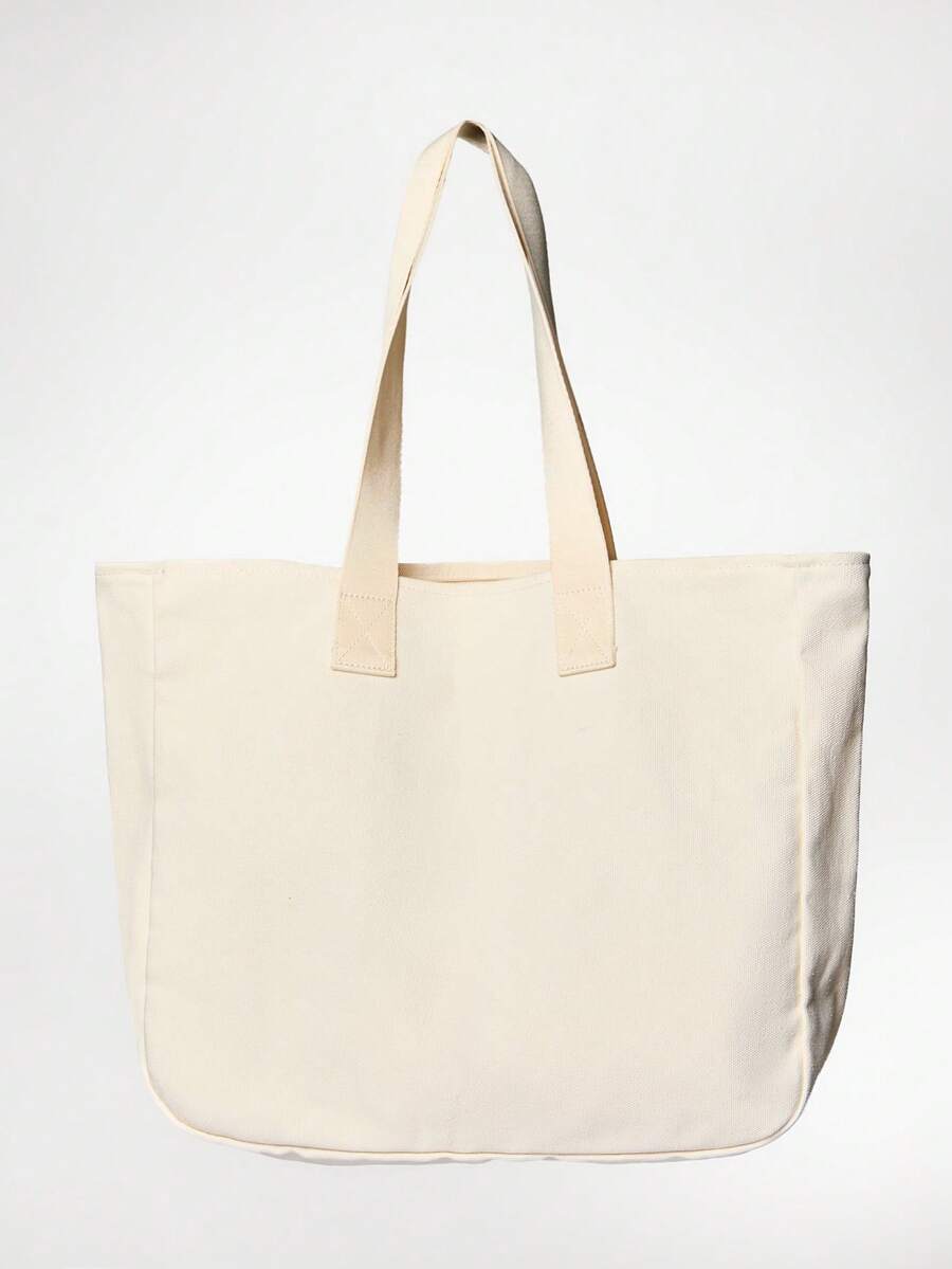 Close view of brown logo tote with boxed bottom and reinforced straps