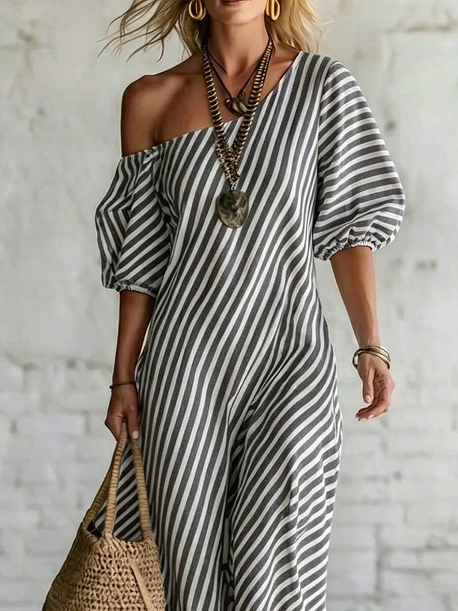 Front crop of grey striped one shoulder dress with voluminous sleeves and straw bag