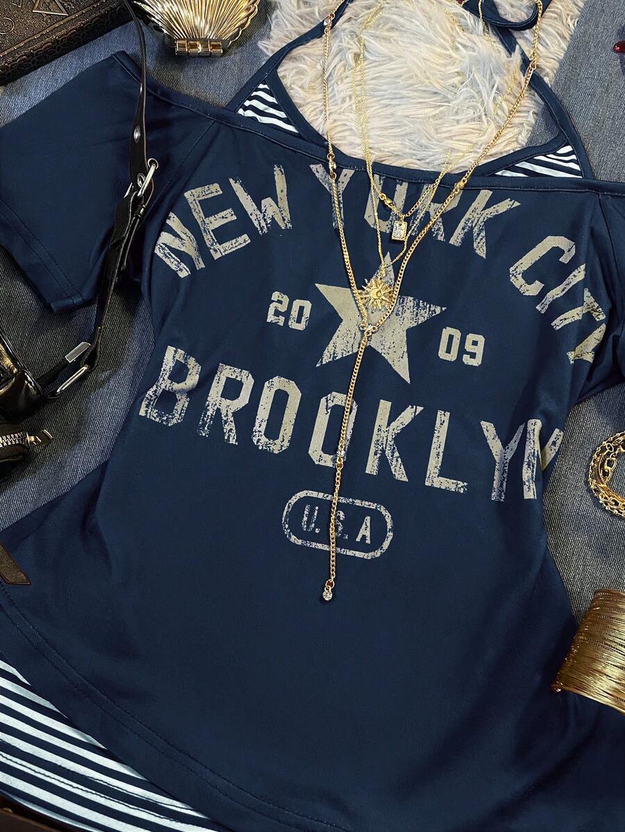 Close-up of navy New York graphic top with striped insert and distressed lettering