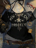 Front flat lay of black layered graphic T-shirt with striped halter insert and New York print