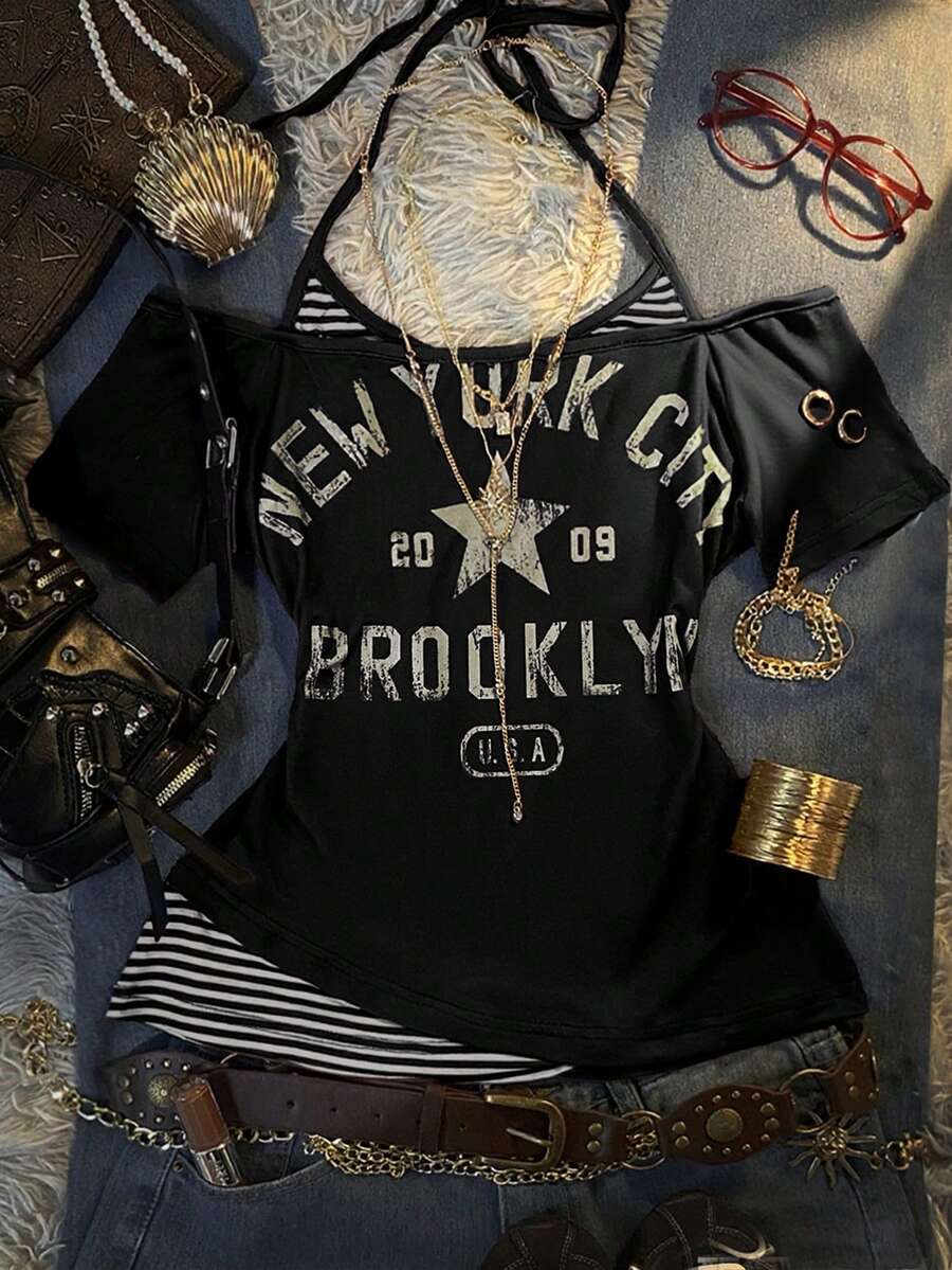 Front flat lay of black layered graphic T-shirt with striped halter insert and New York print