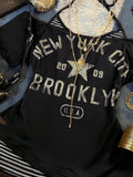 Close-up of black New York graphic top with distressed Brooklyn lettering and star motif