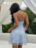 Back view of black floral embroidered spaghetti strap mini dress with straight back