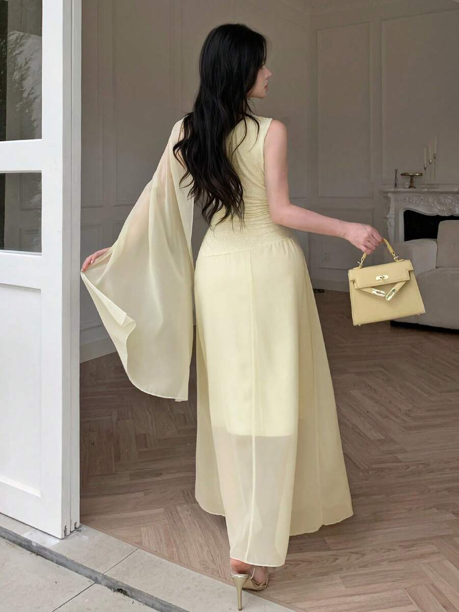 Front view of pale yellow asymmetrical draped chiffon maxi dress showing visible color, trim, and silhouette