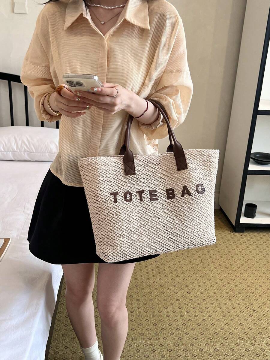 Hand carried view of beige crochet tote bag with openwork body and wide shape