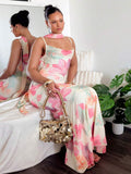Seated front side view of floral mesh maxi dress with flowing fishtail hem