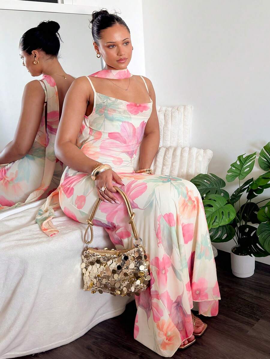 Seated front side view of floral mesh maxi dress with flowing fishtail hem
