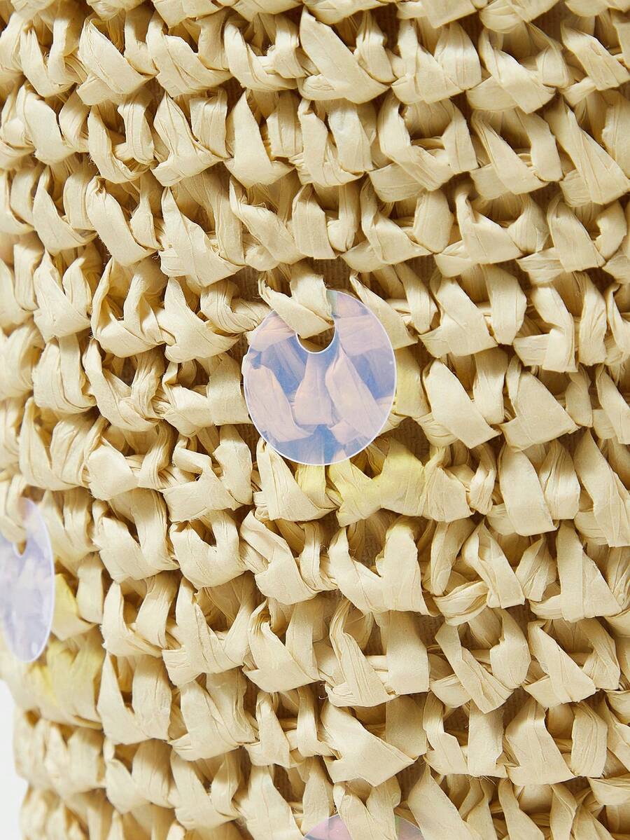 Close view of woven fish bag with cream pouch top and braided raffia texture