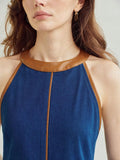 Close-up of dark indigo denim dress high halter neckline and camel brown trim