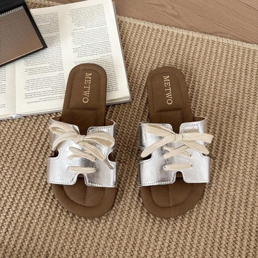 7 media show lace-up flat slide sandals in cream, black, metallic silver and cream black polka dots with H-cut wide vamp strap, sneaker-lace detail, open toe, backless slip-on, brown padded METWO footbed and thin black outsole. image 5