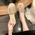 4 media show black and beige flat slide sandals with single wide vamp band, glossy footbed, rounded square toe, rhinestones, pearls, multicolor oval gems, bead rows and floral crystal clusters. image 4