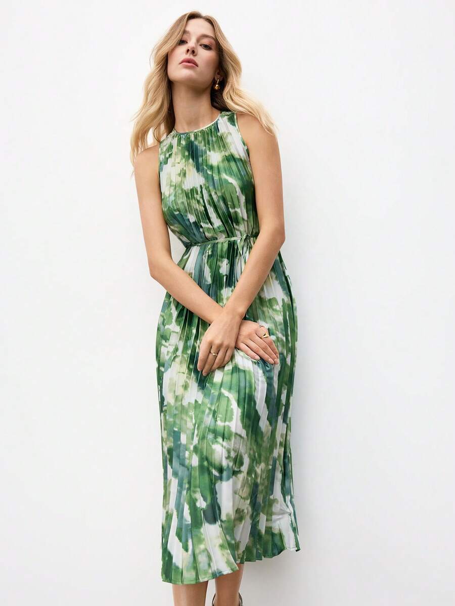Three-quarter front view of green and white tie-dye pleated midi dress with waist belt and flared skirt