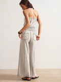 Back view of light stone strapless jumpsuit with gathered waist and rear patch pockets