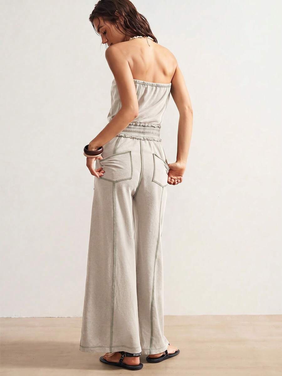 Back view of light stone strapless jumpsuit with gathered waist and rear patch pockets