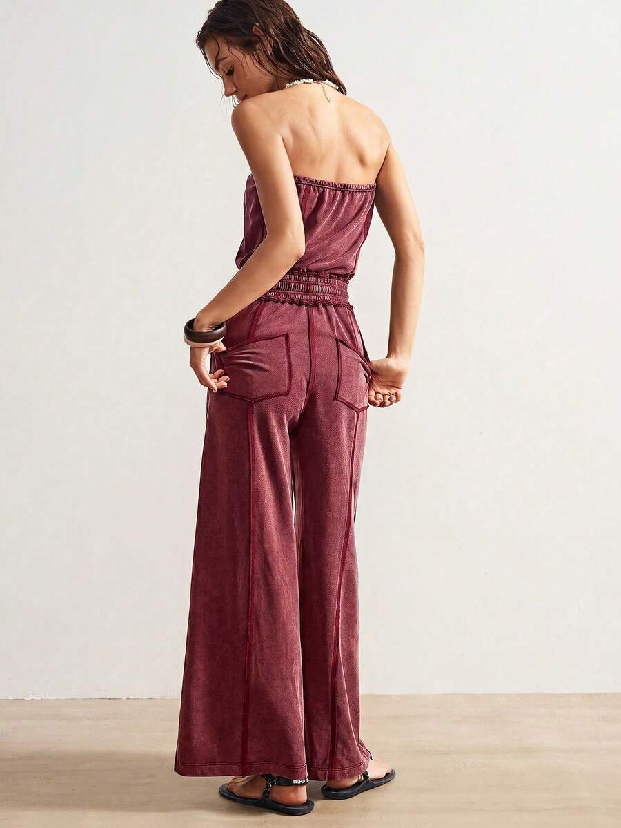 Back view of deep burgundy strapless jumpsuit with rear patch pockets and wide legs