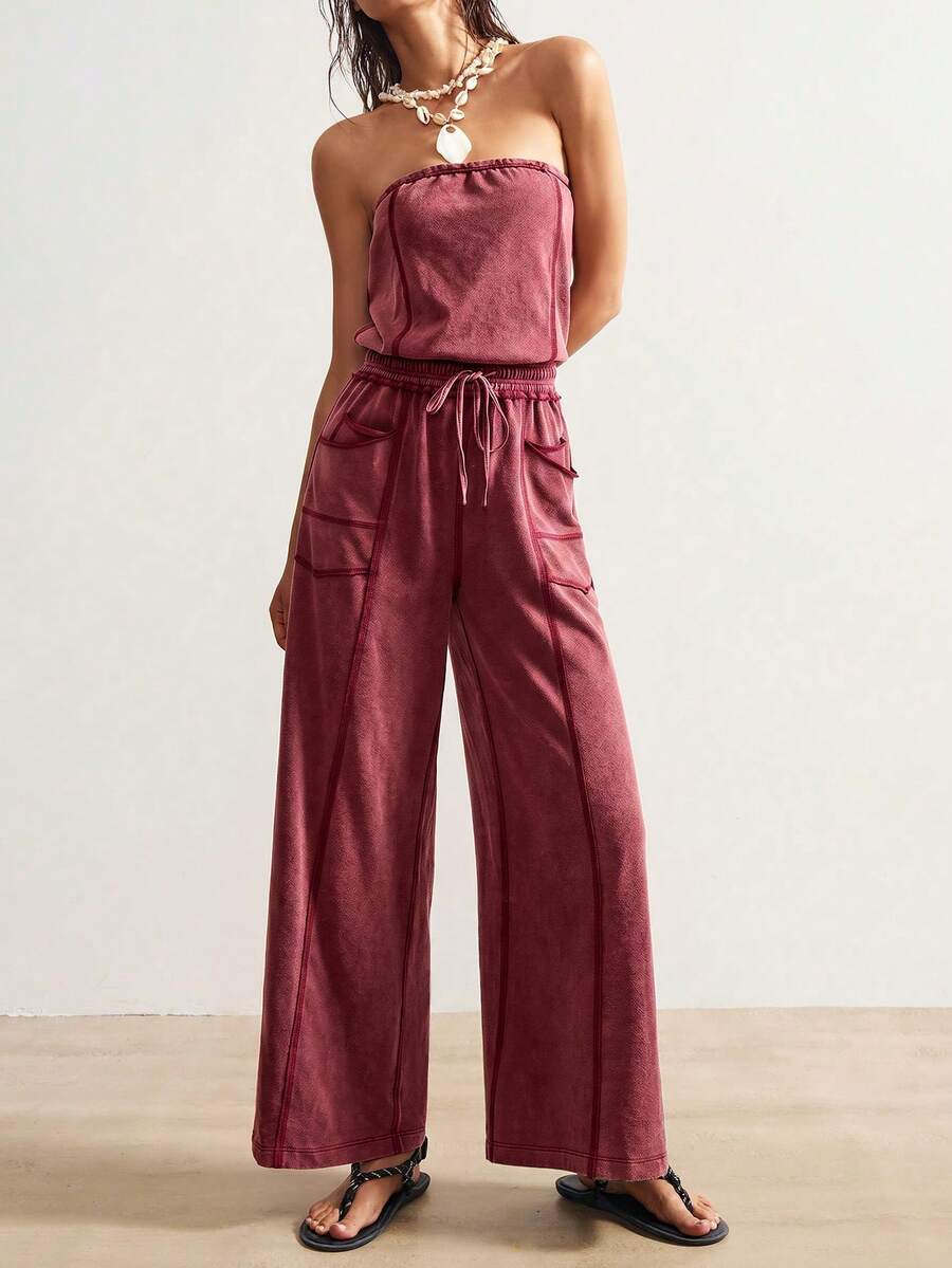 Front view of deep burgundy strapless wide-leg jumpsuit with drawstring waist and pockets