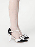 Pair of black and white bow pumps showing pointed toes and slim stiletto heels