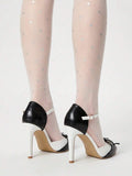 Close-up of black and white ankle strap pump with bow detail and buckle