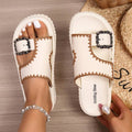 Cream white platform slide sandals with tan trim and decorative buckle