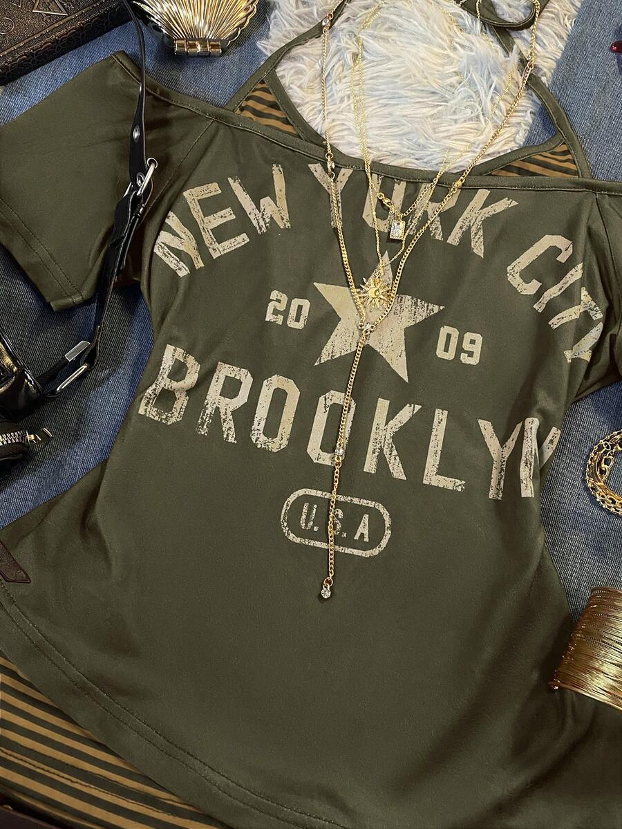 Close-up of olive New York graphic top with distressed Brooklyn lettering and striped insert