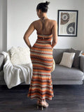 Back standing view of open back geometric stripe halter maxi dress