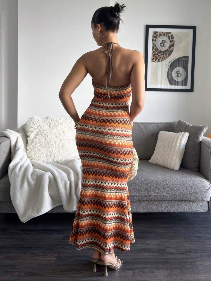 Back standing view of open back geometric stripe halter maxi dress
