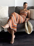 Seated angled front view of orange cream striped bodycon maxi dress