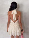 Back view of apricot halter mini dress with tied neck and open V back