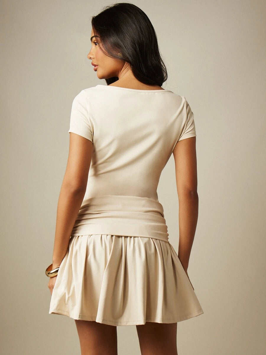 Back view of apricot drop waist mini dress with fitted bodice and flared frill hem