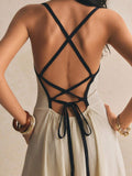 Close-up back view highlighting the crossed black spaghetti straps, open back, tie fastening, and apricot fabric