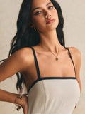 Close-up front view of the apricot dress showing the square neckline, black strap trim, and textured woven fabric