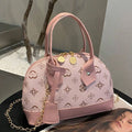 Pink monogram mini handbag with double top handles gold zipper pulls and decorative charm detail
