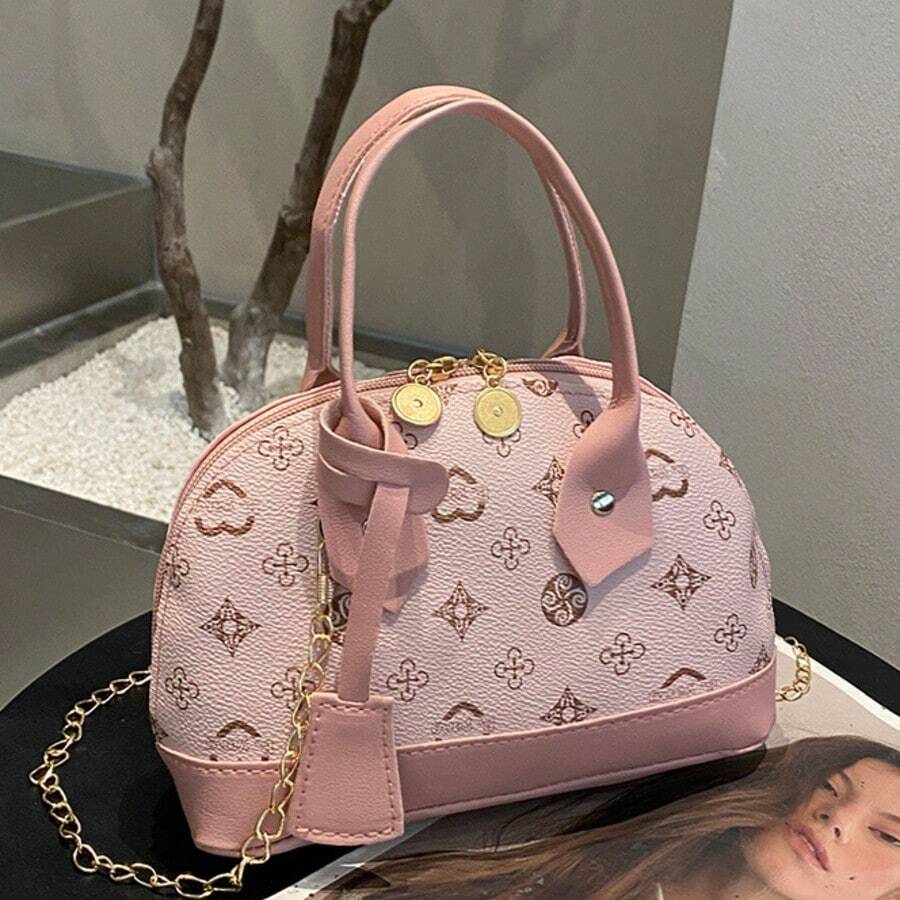 Pink monogram mini handbag with double top handles gold zipper pulls and decorative charm detail