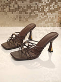 Front product view of brown woven-strap heeled sandals with open square toes and ring ornaments
