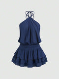 Back view of navy blue backless halter mini dress with shirred waist