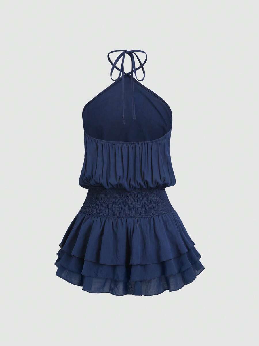 Back view of navy blue backless halter mini dress with shirred waist