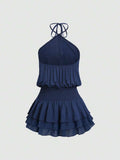 Navy blue sleeveless mini dress showing gathered bodice and flowing ruffles