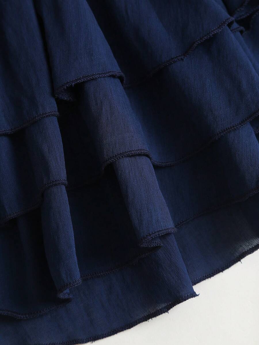 Navy blue halter mini dress with tie neckline and tiered ruffle hem