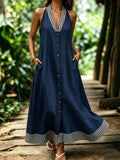 Outdoor view of navy gingham trim halter dress with pockets and flared hem