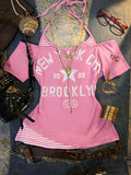 Front flat lay of pink layered graphic T-shirt with New York print and striped halter insert